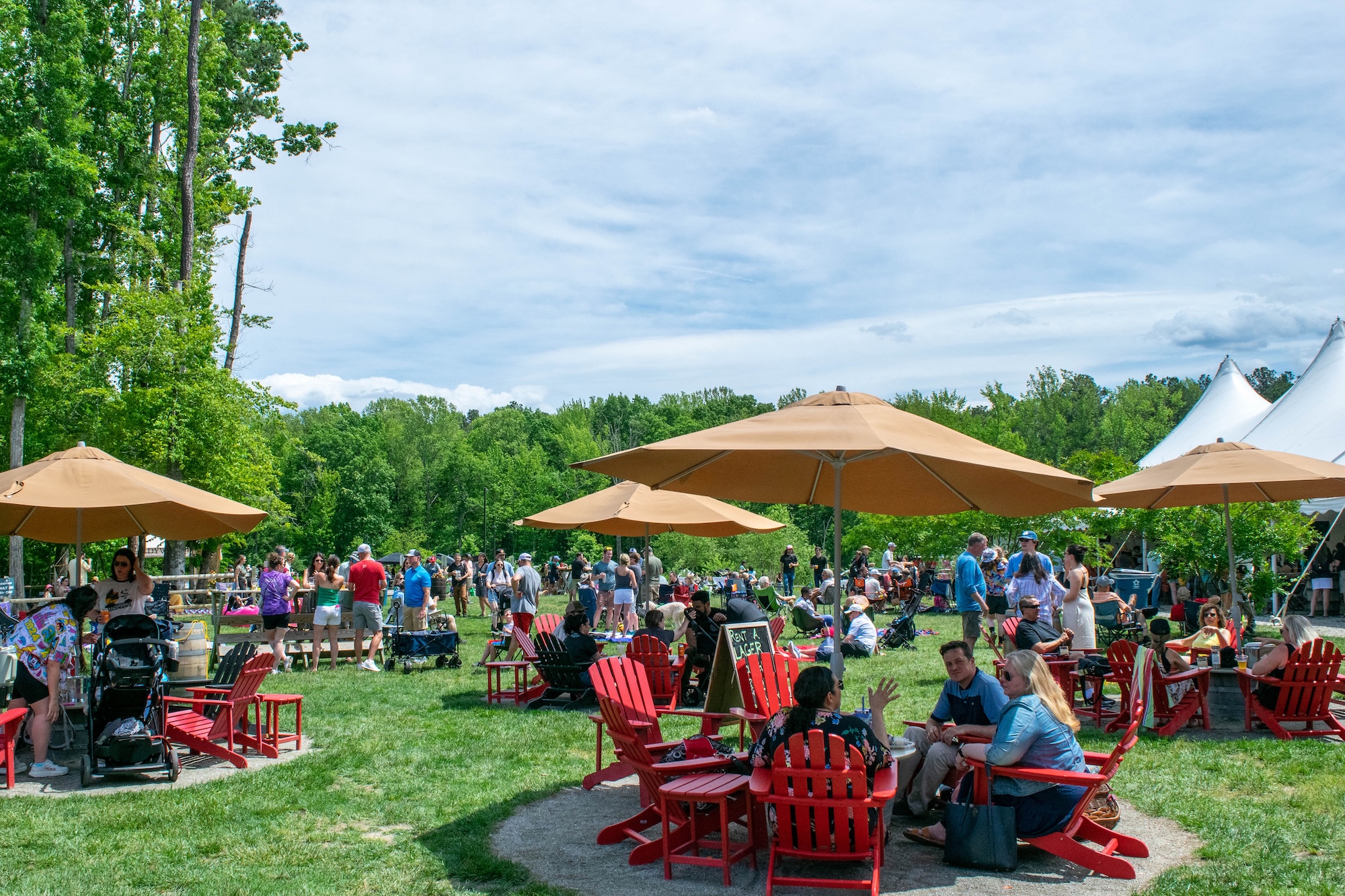 RVA Taco Festival 2026 - Exterior view of Hardywood West Creek with people at tables with red chairs and umbrellas