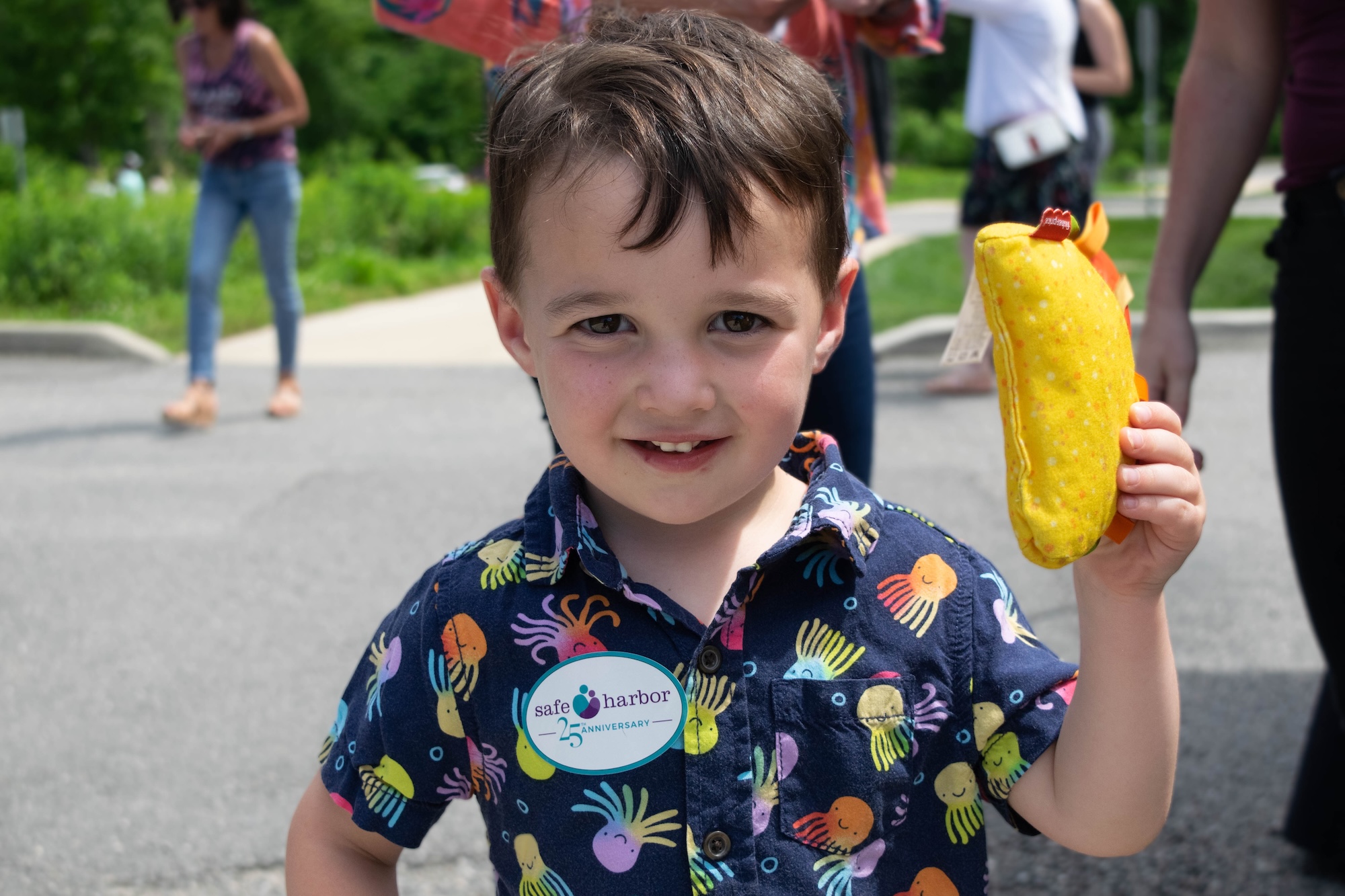 RVA Taco Festival 2026 - Young boy holding up a plush taco and wearing a Safe Harbor sticker